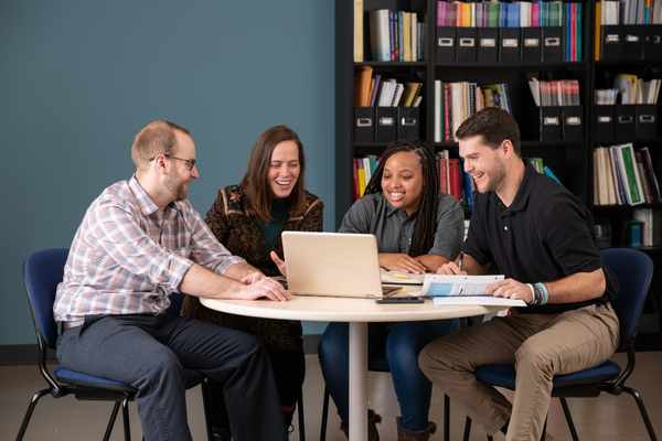 A group of students studying together at a round table. 