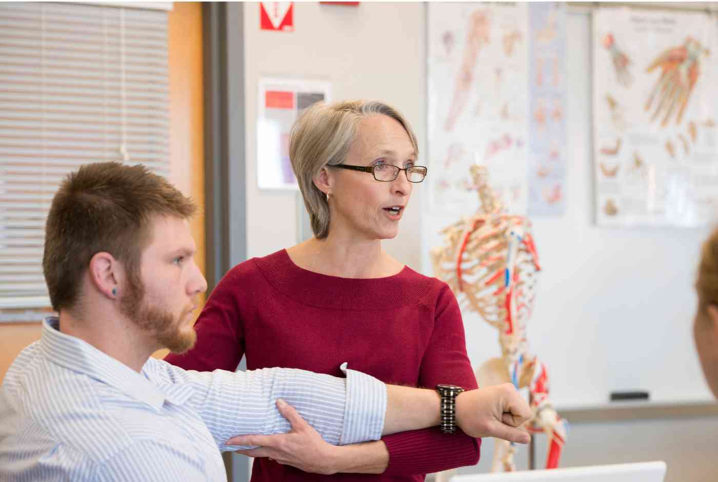 A teacher is using a student in class to demonstrate occupational therapy