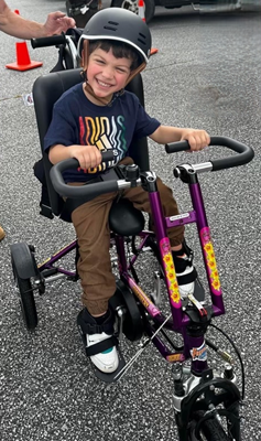 A little boy on an adaptive bike.
