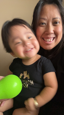 Mickie and a child in her arms smile for the camera.