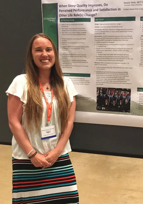 Natalie Rolle poses in front of her poster presentation on sleep quality.